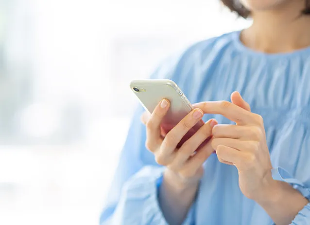 スマートフォンで問い合わせをしている女性
